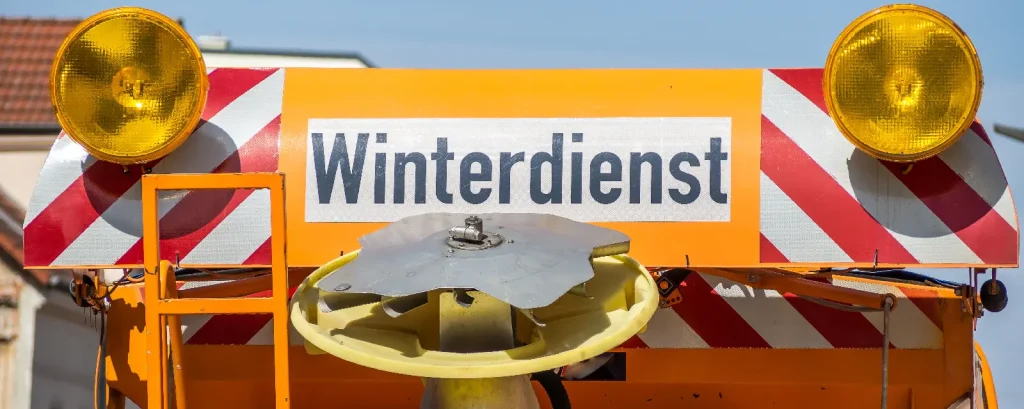 Winterdienst-Anbieter auswählen: Heck eines Winterdienstfahrzeugs mit Streutechnik, Warnleuchten und Sicherheitsmarkierungen.