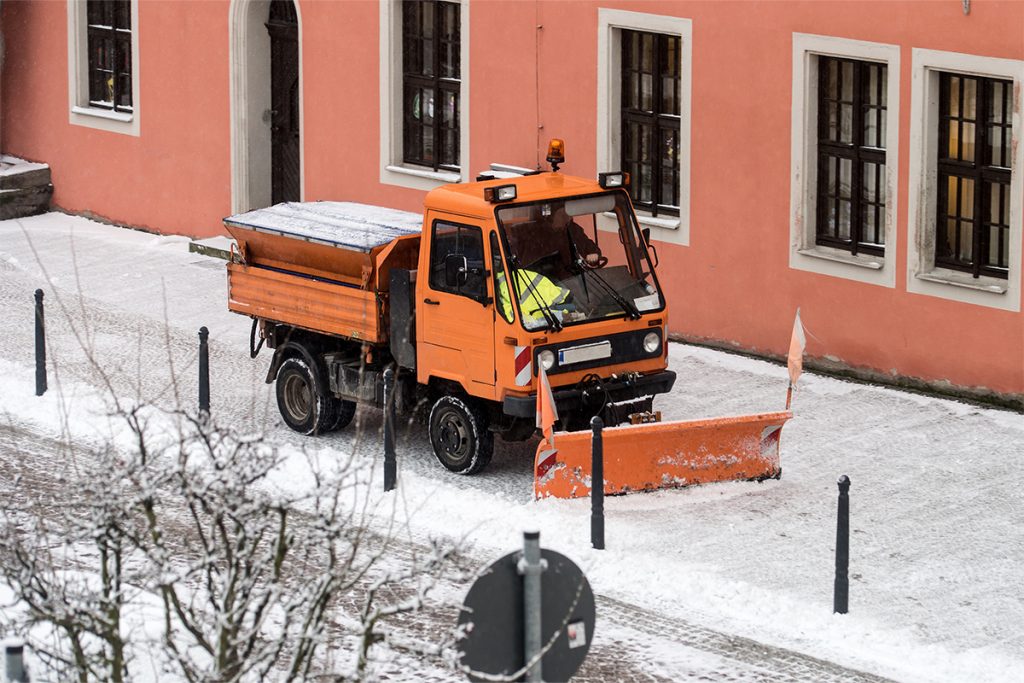Winterdienst-Fahrzeug räumt verschneite Straße – Umsetzung der Verkehrssicherungspflicht Winter und Dokumentation Winterdienst im öffentlichen Raum.
